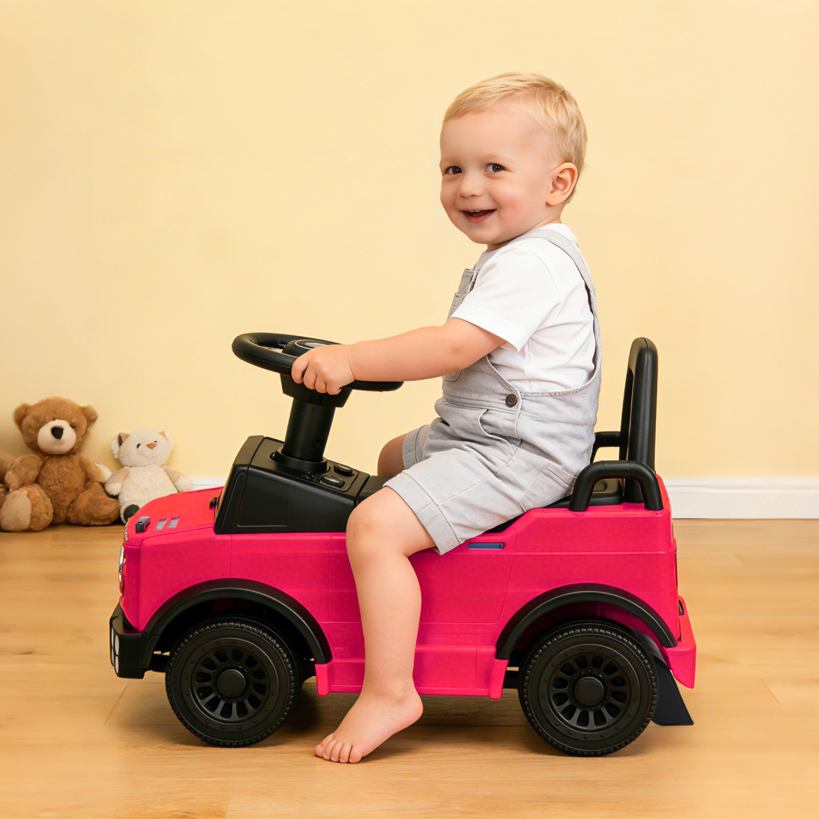 Side view of a toddler boy riding the pink Mercedes-Benz Unimog licensed push car, demonstrating the foot-to-floor design that helps children under 2 practice balance and coordination in an indoor setting.